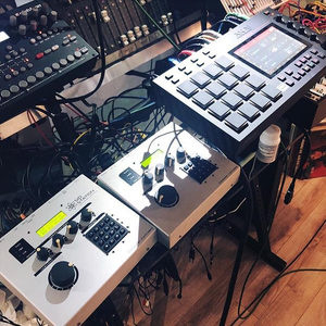 Akai MPC Live next to a SIDstation and outboard gear on a Zombie Nation studio desk, cables clearly visible