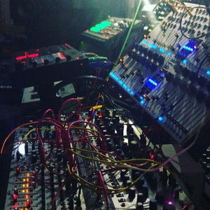 WMD Performance Mixer and Eurorack modules under stage lighting, densely patched with colourful cables