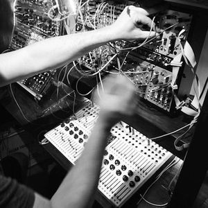 Black and white overhead shot of patching a large Zombie Nation modular synthesizer, fader controller below