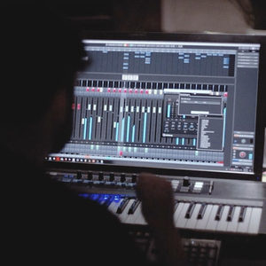 Over-shoulder shot of a producer working on a Cubase arrangement in the dark Zombie Nation studio