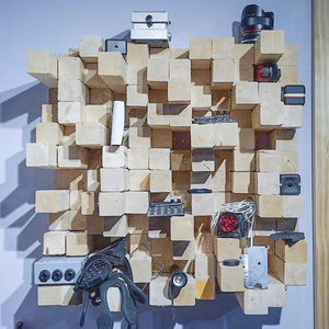 Custom wooden acoustic diffuser panel of staggered blocks on the Zombie Nation studio wall, gear in the
