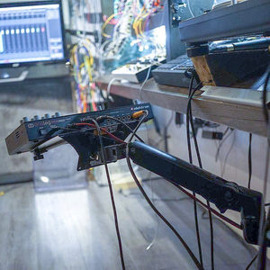 Zombie Nation studio desk underside view, Elektron device on a monitor arm, modular synthesizer visible