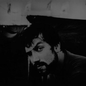 Florian Senfter dramatic black and white close-up portrait, half the face in deep shadow, intense gaze