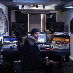 Motion-blurred Zombie Nation studio session at a large mixing console with Genelec monitors and a turntable