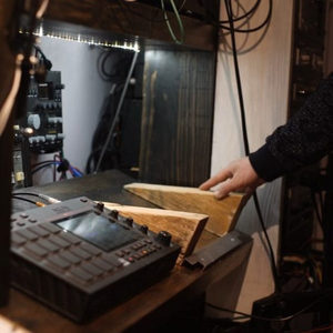 Zombie Nation studio desk with Akai MPC Live alongside a rough timber slab being fitted as a back panel