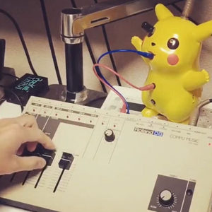 Pikachu toy sitting on a Roland DG Compu Music sequencer, blue and pink patch cables, Zombie Nation studio