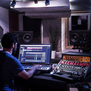 Zombie Nation studio at night, producer at the desk from behind with Cubase open, large studio monitors