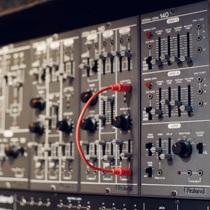 Roland System 100m modular synthesizer front panel with a red patch cable, Zombie Nation studio collection