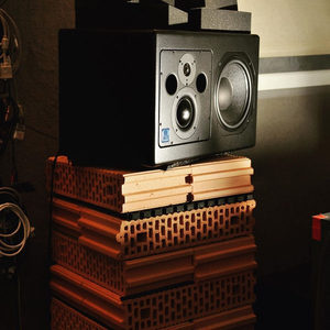 Zombie Nation studio monitor raised on a stack of red terracotta building bricks as an improvised