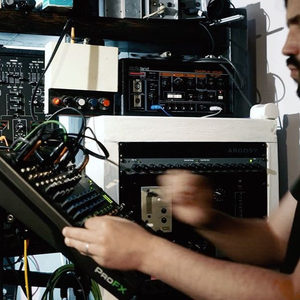 Producer adjusting an Argosy Space Station in a rack, Roland Chorus Echo above, ProFX mixer below