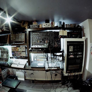 Fisheye view of the full studio showing a large modular synthesizer rack, mixing desk and outboard gear