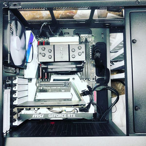 Open PC tower case showing an MSI GeForce RTX graphics card, CPU cooler and white motherboard components